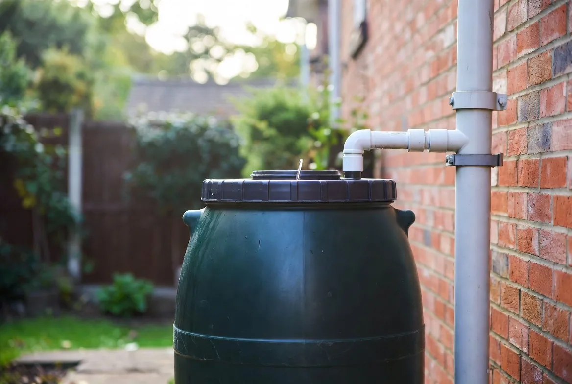 A covered water butt connected securely to a house downpipe